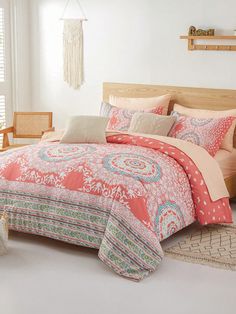 a bed with pink and orange comforters in a room