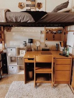 a loft bed with desk underneath it in a room filled with shelves and drawers on the wall