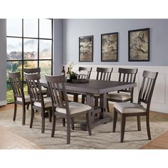 a dining room table with six chairs and a bench in front of a large window