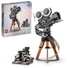 a lego movie camera on a tripod with mickey mouse and other toys in front of it