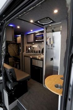 the inside of a camper with a kitchen and dining area in it's back