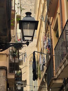 iPhone photo of Barcelona balconies with street lamp, hanging laundry and plants. Gothic church in the background Spain Vintage Aesthetic, Spain Life Aesthetic, Life In Spain Aesthetic, Spain Barcelona Aesthetic, Barcelona Spain Aesthetic, Spain Aesthetics