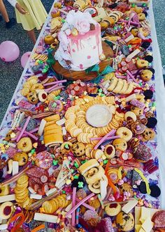 a long table covered with lots of different types of food and desserts on it