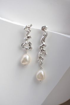 These freshwater pearl earrings made in author's technique with raw silver  Materials: * 925 Sterling Silver  * Freshwater pearls Dimensions: * Silver part size: 2 - 3,5 cm * Pearl Size: aprox. 0.7-0.8 cm * Sold As One Pair Usage: Keep away from perfume and chemicals in the products you buy. Package: All our jewellery come in a nice jewellery box, in which it is comfortable to store and pleasant to gift Elegant Silver Freeform Earrings, Silver Baroque Pearl Single Earring, Single Silver Baroque Pearl Earring, Silver Baroque Pearl Dangle Earrings, Silver Drop Earrings With Baroque Pearl, Freshwater Pearl Earrings, Freshwater Pearls Earrings, Pearl Size, Jewelry Earrings Hoops