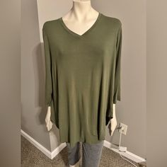 Elevate Your Wardrobe With This Stunning Cato Blouse In A Soft Green Color. The Top Boasts A Flattering V-Neckline And 3/4 Sleeves, Making It A Versatile Piece For Any Occasion. The Pullover Style Adds Ease To Your Everyday Dressing, While The Stretch Feature Ensures A Comfortable Fit. This Blouse Comes In A Plus Size Of 18w And Is Machine Washable For Your Convenience. It Is A Solid Pattern With No Tags Attached, Perfect For Those Who Appreciate Simplicity. The Garment Care And Fit Are Well-Sui Green V-neck Tunic For Fall, Casual V-neck Tunic For Layering, Casual Solid V-neck Tunic, Green Stretch Top With 3/4 Sleeves, Casual V-neck Tunic For Fall, Oversized Green Tops With 3/4 Sleeves, Soft Green Color, Neck Stretches, Stylish Blouse