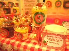 cupcakes and other desserts are on display at the table with red and white checkered cloth