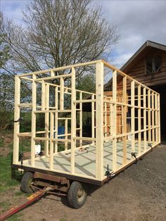 a trailer is being built in front of a house with wood framing on the side