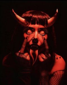 a woman with horns on her head and hands in front of her face