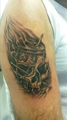 a man's arm with a skull and drum on it