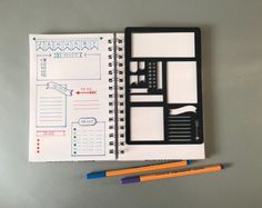 an open planner book with two pencils on the side and a notepad next to it