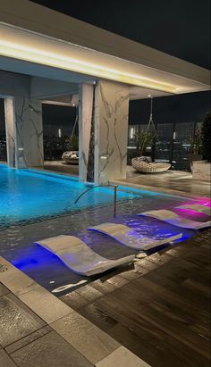 an indoor swimming pool with blue and pink lights