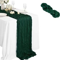 the table is set with white plates and green napkins