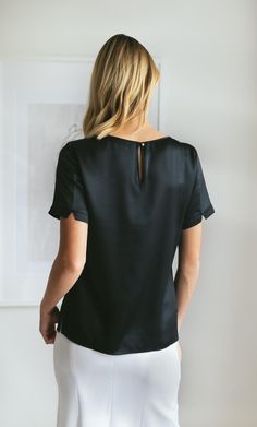 FREE US SHIPPING, FREE RETURNS This elevated short-sleeve silk tee is a refined take on a wardrobe classic. The minimalist silhouette is accented with a boatneck neckline and elegant keyhole closure on the back. Tailored sleeves feature v-slit detailing and above-the-elbow fit. Year-round favorite. Wear alone or pair with a blazer. Minimalist gold button and keyhole closure on the back. Hits just below the hips with side slits. Great tucked or untucked. 100% MULBERRY CHARMEUSE SILK – Washable Silk Tee, Wardrobe Classic, Satin Blouses, Silk Robe, Black Caviar, French Seam, Luxury Silk, Fashion 2020, Mulberry Silk