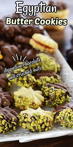 egyptian butter cookies with chocolate and crushed nuts on a white platter next to other desserts