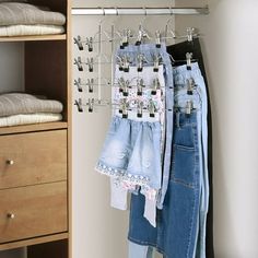 clothes hanging on a rack in a closet next to a dresser with drawers and shelves