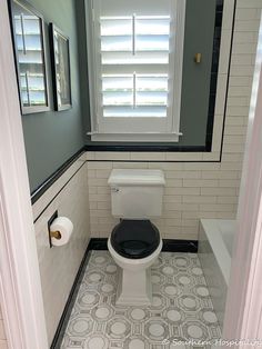 a white toilet sitting in a bathroom next to a window