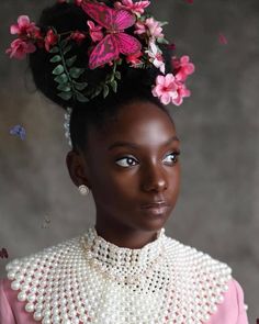 a woman with flowers in her hair and pearls around her neck, wearing a pink dress