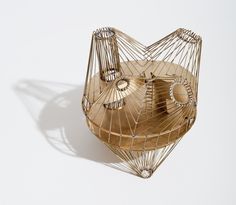 a metal bird cage sitting on top of a white table next to a wooden bowl