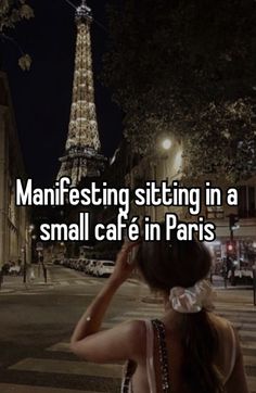 a woman standing in front of the eiffel tower with her hand on her head