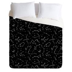 a black and white comforter with stars on the night sky in front of it