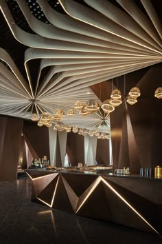 the interior of a modern restaurant with lights and chandeliers hanging from the ceiling