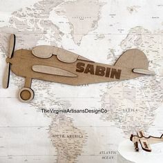 a wooden airplane cut out on a map with the word sabin written in it