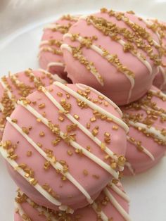 pink and white cookies with gold sprinkles on a plate