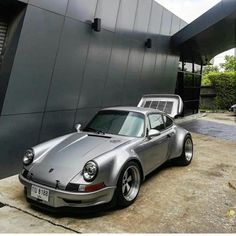 a silver porsche parked in front of a building