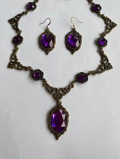 STUNNING FILIGREE VICTORIAN STYLE PURPLE dark gold PLATED (Bronze Colour) NECKLACE SET WITH A CHOICE OF EARRING   FASTENS WITH TRIGGER CLASP.  EARRINGS APPROX 2.5 INCHES 6 CM INCLUDING  EAR WIRES.    PENDANT APPROX  1.75 INCHES (4cm) INCLUDING BAIL Length necklace 16 inches as shown (40cm) also available in 18. 20. 22. 24 inch lengths...45 50 55  60 Longer ones have more parts and /or stones IF instead YOU WOULD LIKE THE MATCHING SLENDER EARRINGS OR JUST THE SMALL OVAL, LET ME KNOW WHEN YOU BUY Dark Purple Jewelry, Dark Purple Accessories, Dark Purple Necklace, Purple Victorian Necklace For Gift, Ornate Purple Dangle Jewelry, Dark Academia Accessories, Ornate Purple Pierced Earrings, Victorian Jewelry Necklace, Goth Jewelry Violet Vixen