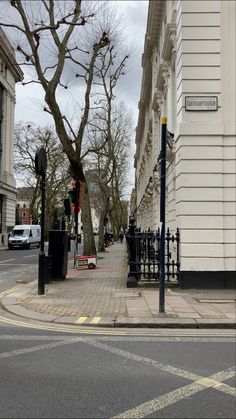 an empty city street with cars parked on the side