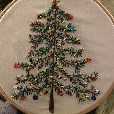 a hand embroidered christmas tree with colorful ornaments