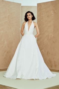 a woman in a white wedding dress posing for the camera with her hands on her hips