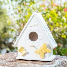 a white birdhouse sitting on top of a rock