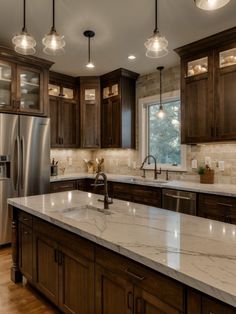 a large kitchen with marble counter tops and wooden cabinets, along with stainless steel appliances