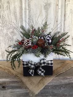 a christmas arrangement in a black and white container