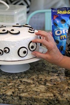 a cake with googly eyes on it being held up by someone's hand