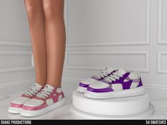 a pair of shoes with purple and white colors are shown on a pedestal in front of a woman's legs