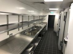 an empty kitchen with stainless steel counters and sinks