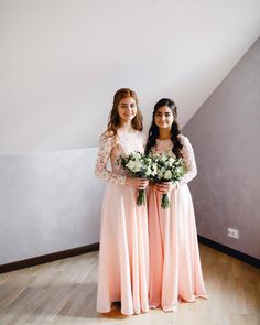 two girls in long dresses standing next to each other