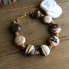 Fall bracelet brown Jasper natural stone coin bracelet fashion gold bracelet boho stone bracelet gift unique jewelry bracelet for women 6 Length: 6.5 inches approx Who doesn't love a beautiful bracelet. I search the world over for some of the best stones and beads and also create my own so you can jazz up that most forgotten wrist. Treat yourself or someone special to something unique. This bracelet has 14mm natural stone painted Arizona Jasper beads, Bali beads, gold plated findings, lobster cl Brown Round Gemstone Beads Jewelry, Brown Natural Stones Round Jewelry, Handmade Brown Bracelet Jewelry, Handmade Brown Bracelet, Gold Earthy Bracelets With Round Beads, Bohemian Round Brown Jewelry, Bohemian Brown Round Jewelry, Earthy Brown Round Jewelry, Brown Round Bracelets For Jewelry Making