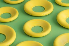 many yellow donuts are arranged on a green surface