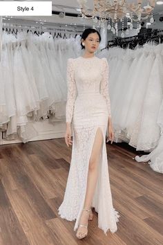 a woman standing in front of a rack of wedding dresses