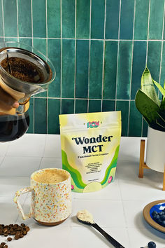 coffee being poured into a cup next to a bag of wonder mct on a counter