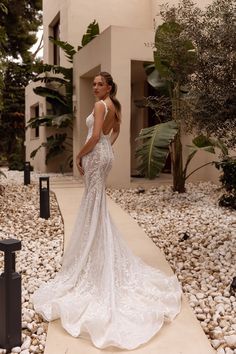 a woman in a wedding dress standing on rocks