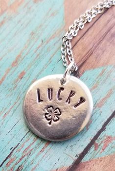 You are one of kind, let your jewelry be the same!These hand formed 7/8 inch pewter pebbles are each totally unique are stamped with "lucky" and a 4 leaf clover.  These necklaces make great and beautiful statements.  Smooth lead free pewter also serves as a great worry stone!.*all items are made to order, colors, fonts and designs may vary. If you want something specific please message me prior to purchase. Spiritual Hand Stamped Round Pendant Jewelry, Spiritual Hand-stamped Round Pendant Jewelry, Spiritual Hand Stamped Jewelry With Round Pendant, Meaningful Hand Stamped Sterling Silver Charm Necklaces, Meaningful Hand Stamped Sterling Silver Charm Necklace, Silver Hand Stamped Meaningful Charm Necklace, Adjustable Stamped Sterling Silver Charm Necklaces, Adjustable Sterling Silver Stamped Charm Necklace, Adjustable Hand Stamped Charm Necklace With Round Pendant