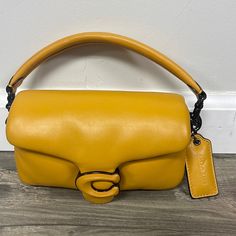 Nappa Leather Inside Multifunction Pocket Snap Closure, Fabric Lining Detachable Handle With 4" Drop Detachable Long Strap With 21 1/2" Drop For Shoulder Or Crossbody Wear 7 1/4" (L) X 4" (H) X 2 1/2" (W) Style No. C3880 Yellow Double Handle Coach Shoulder Bag, Elegant Yellow Coach Shoulder Bag, Coach Yellow Crossbody Shoulder Bag, Coach Pillow Tabby, Coach Yellow Shoulder Bag With Gold-tone Hardware, Coach Pillows, Coach Yellow Bag With Gold-tone Hardware, Pillow Tabby, Bags Coach