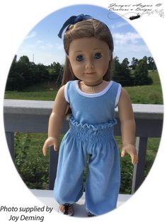 the doll is wearing blue overalls and sandals