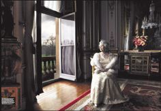 a woman sitting in a chair next to a window