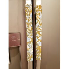 two yellow and white curtains hanging on the side of a door with a sign next to it