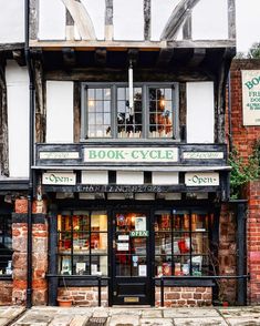 an old building with books on display in the window and sign above it that says book cycle